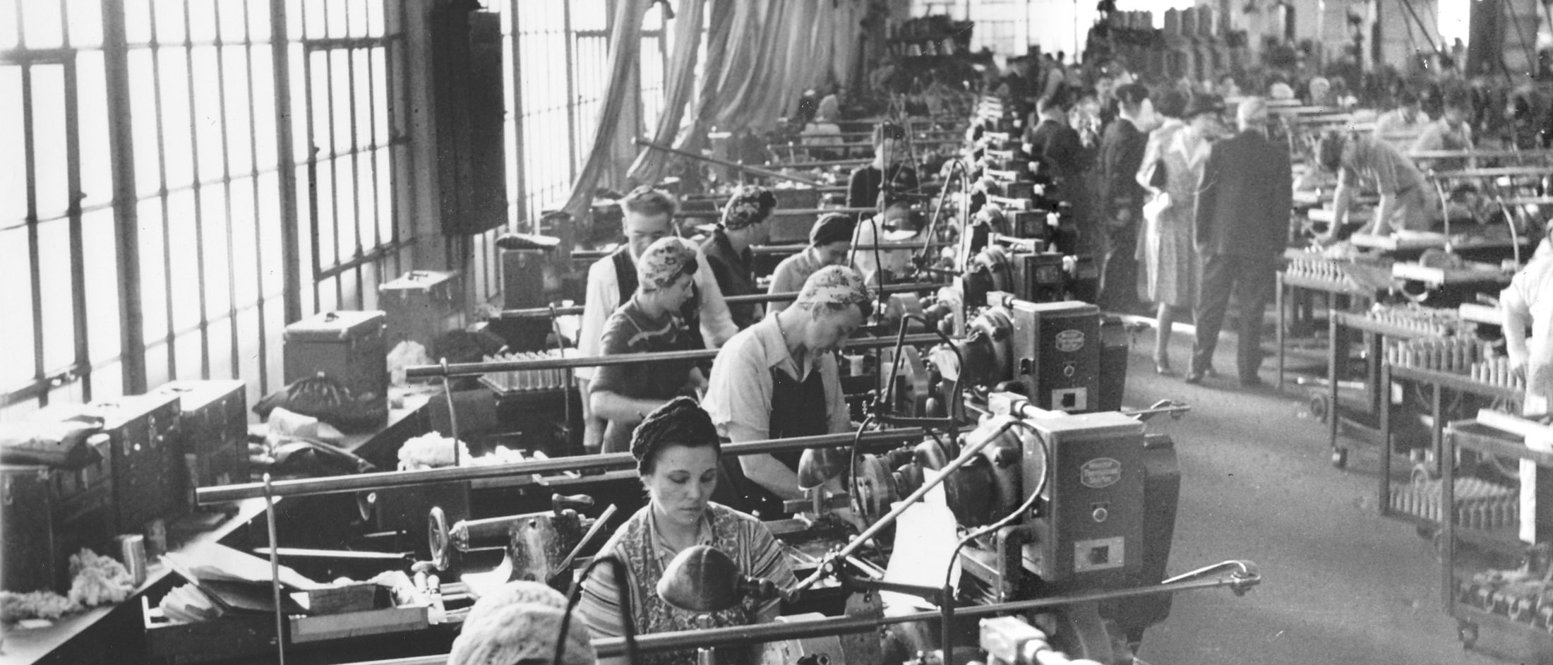 Lathe operators working a long row of machines on a factory floor, Washington Navy Yard, January 1943